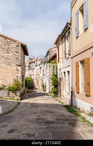 Rue étroite en pente avec de vieilles maisons colorées dans l'ancienne ville d'Arles en Provence, dans le sud de la France. Banque D'Images