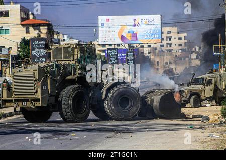 Un bulldozer militaire israélien enlève les décombres du sol en prévision de l ' entrée d ' un grand nombre de véhicules destinés à réprimer les manifestants palestiniens, lors d ' une manifestation de soutien à Gaza, qui fait l ' objet de frappes aériennes israéliennes depuis octobre 7, près du poste de contrôle de Hawwara, qui est sous contrôle israélien. Le mouvement de résistance islamique Hamas a appelé tous les Palestiniens de Cisjordanie à affronter les forces israéliennes. Partout en Cisjordanie, en réponse à l'attaque israélienne contre Gaza, qui a coûté la vie à plus de 1 500 citoyens non armés, dont des centaines d'enfants et autres Banque D'Images