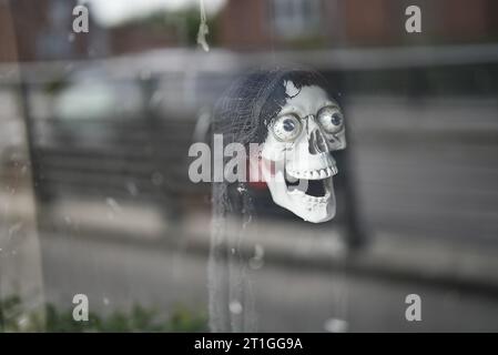 Halloween, crâne accroché en vêtement blanc, célébrant des vacances mystiques Banque D'Images