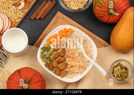 Flocons d'avoine avec citrouille et noix. Plat de saison, bouillie de citrouille avec graines, noix et flocons d'avoine, plat Banque D'Images