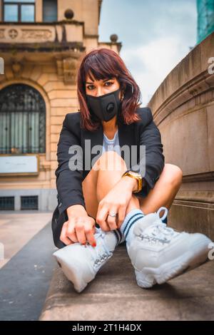 Une jeune brune avec un masque facial de la pandémie de coronavirus. Déconditionnement après covid-19 Banque D'Images