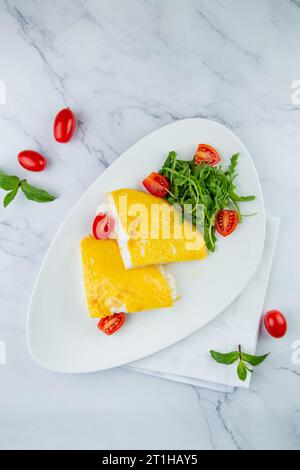 Grande omelette française avec roquette et tomates cerises vue de dessus Banque D'Images