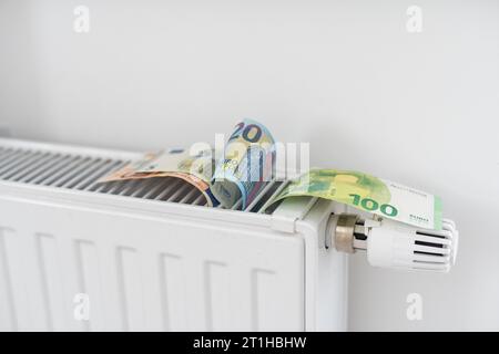 billet de banque couché sur le radiateur, le concept de la hausse des prix de l'énergie et le chauffage plus cher Banque D'Images