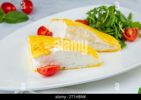 Grande omelette française avec roquette et tomates cerises vue de côté Banque D'Images