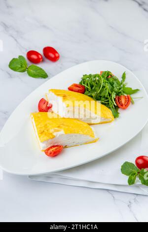 Grande omelette française avec roquette et tomates cerises vue de côté Banque D'Images