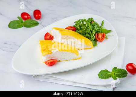 Grande omelette française avec roquette et tomates cerises vue de côté Banque D'Images