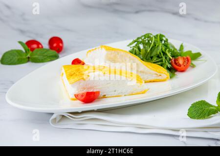 Grande omelette française avec roquette et tomates cerises vue de côté Banque D'Images
