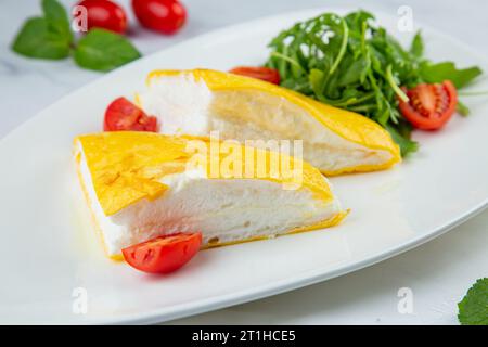 Grande omelette française avec roquette et tomates cerises vue de côté Banque D'Images