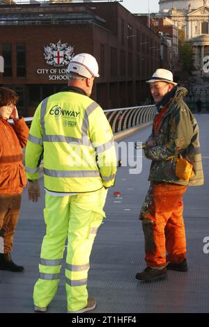 Londres, Royaume-Uni 14/October/2023 Chewing Gum Artist lutte contre le temps pour sauver le travail le Millennium Bridge, la célèbre passerelle de l'autre côté de la Tamise, ferme pour restauration. La fermeture est source de controverse car les œuvres d'art peintes sur du chewing-gum à la surface du pont seront nettoyées. Juste avant la fermeture, un représentant des entrepreneurs travaillant sur le pont négocie avec l'artiste Ben Wilson. Wilson travaille jusqu'à la dernière minute pour couvrir son art miniature pour le protéger des nettoyeurs haute pression. Crédit : Roland Ravenhill/Alamy. Banque D'Images