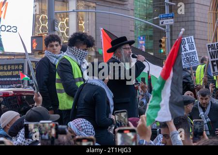 New York, États-Unis. 13 octobre 2023. Un membre de Neturei Karta un culte juif orthodoxe anti-sioniste tient un drapeau palestinien lors d'une manifestation palestinienne une Journée d'action à Times Square à New York. Partout au pays et dans le monde, des gens organisent des rassemblements et des veillées pour les Palestiniens et les Israéliens suite à une attaque surprise du Hamas le 7 octobre. L ' attaque a entraîné un bombardement de Gaza par l ' armée israélienne et une possible invasion terrestre du territoire. Crédit : SOPA Images Limited/Alamy Live News Banque D'Images