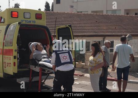 Une israélienne reçoit une assistance médicale alors qu’elle est évacuée dans une ambulance après qu’une roquette, tirée par des militants palestiniens de la bande de Gaza, ait touché sa maison le 8 octobre 2023 à Sderot, en Israël. Samedi, le groupe militant palestinien Hamas a lancé la plus grande attaque surprise depuis Gaza depuis une génération, envoyant des milliers de missiles et un nombre inconnu de combattants par terre, qui ont tiré et kidnappé des Israéliens dans des communautés proches de la frontière de Gaza. Banque D'Images