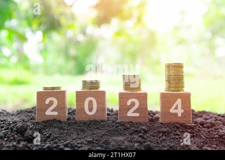 Année 2024 succès financier et concept d'argent croissant. Pile croissante de pièces au lever du soleil. Banque D'Images