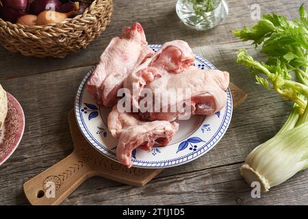 Dos de poulet congelés et légumes frais sur une assiette - Ingrédients pour bouillon d'os ou soupe Banque D'Images