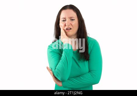 Femme hispanique portant des vêtements décontractés verts touchant la bouche avec la main avec une expression douloureuse due à un mal de dents ou une maladie dentaire sur les dents sur le dos blanc Banque D'Images
