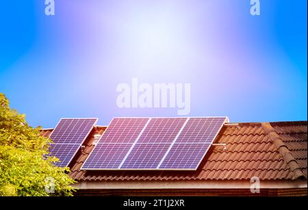 Panneaux solaires sur le toit carrelé de la maison au soleil. Production d'électricité pour ses propres besoins et pour la vente avec espace de copie. Banque D'Images