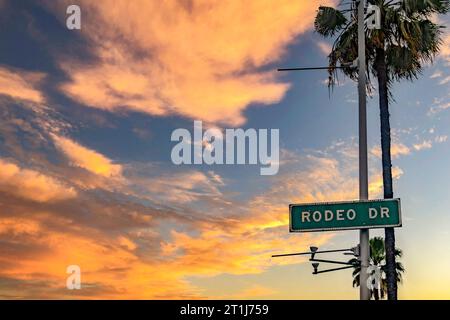 Magnifique panneau de rue Rodeo Drive à Beverly Hills dans la ville de Californie aux États-Unis d'Amérique, sous un ciel orange au coucher du soleil. Banque D'Images