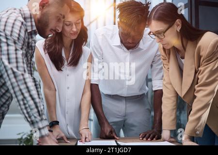 Négocier des rapports de marketing, des graphiques statistiques, travailler ensemble sur un projet de démarrage Banque D'Images