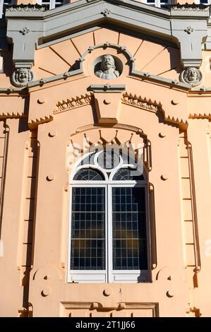 Vue verticale d'une fenêtre avec une statue décorative sur le dessus. Élément architectural dans la façade ou le mur extérieur du Théâtre Romea. Banque D'Images