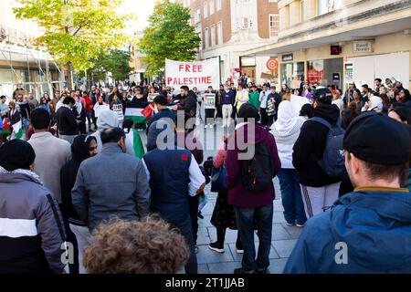 Free Palestine Protest Exeter - une foule nombreuse se tient en cercle avec des manifestants parlant dans un méga téléphone au centre et avec des percussions musicales Banque D'Images