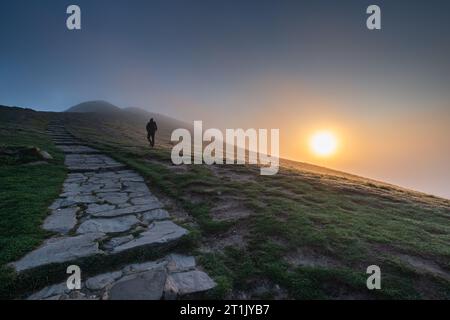 Un homme monte une MAM Tor brumeuse dans le Derbyshire. Banque D'Images