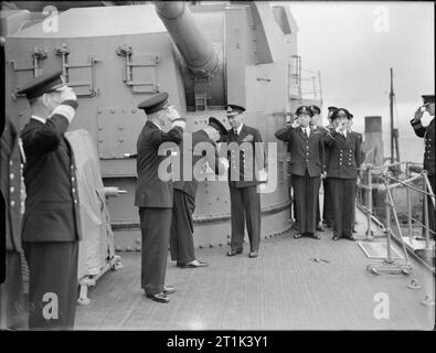 La Royal Navy pendant la Seconde Guerre Mondiale, Sa Majesté le Roi George VI est reçu à bord du HMS DUKE OF YORK par l'amiral Sir John Tovey, commandant en chef de la Home Fleet à Scapa Flow. L'un des deux navires de tourelles de 5,25 pouces peut être vu dans l'arrière-plan. Remarque Les deux hommes à bord, le roi de la tuyauterie. Banque D'Images