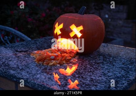 Citrouille drôle Puking Halloween luisant avec visage picking drôle sculpté avec vomi et apparence effrayante dans l'obscurité Banque D'Images