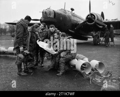 Royal Air Force Bomber Command, 1939-1941. L'équipage d'un bombardier de No 311 (Escadron tchécoslovaque) étude de la RAF une carte, tout en étant assis sur des bombes de 250 lb GP, qui sont sur le point d'être chargés dans leur Mark Vickers Wellington IC à l'East Wretham, Norfolk. Banque D'Images