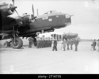 Royal Air Force Bomber Command, 1939-1941. Le premier ministre Winston Churchill, et l'approche de son parti un court Stirling Mark I d n°7 Squadron RAF avec son air et le personnel au sol aligné pour l'inspection, au cours d'un examen des bombardiers britanniques et américains en service avec la RAF à Northolt, Middlesex. Accompagnant le premier ministre, mais masquée par lui, est l'Air Chief Marshal Sir Charles Portal, chef d'état-major de la Force aérienne, suivi par sir Archibald Sinclair, secrétaire d'état de l'air et le vice-maréchal de l'air Trafford Leigh-Mallory, commandant de l'air n°11, groupe de chasse. L'aéronef bordée Banque D'Images