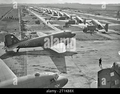 Royal Air Force transport Command, 1943-1945. Douglas Dakotas stationne au B-56 Evere, en Belgique, alors que son fret est déchargé dans des camions de l'armée. Le deuxième avion au premier plan est le Dakota Mark III, KG348 'HC-AO', du détachement du No. 512 Squadron RAF. Deutsch : Royal Air Force transport Command, 1943-1945. Douglas Dakotas in parkposition auf dem Flugplatz B-56 Evere, Belgien, während ihre Fracht in Armeelastwagen entladen wird. DAS zweite Flugzeug im Vordergrund ist die Dakota Mark III, KG348 'HC-ao', der Staffel Nr. 512 der RAF. Banque D'Images