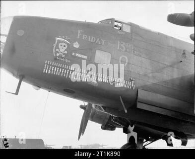 Royal Air Force Bomber Command, 1942-1945. Nez de près de l'insigne sur Handley Page Halifax B Mark III, LV907 'NP-F' 'Vendredi 13', du no 158 Squadron RAF, après son retour de Lissett, Yorkshire, à partir de sa 100e sortie, un raid de nuit sur Gelsenkirchen, Allemagne, piloté par le Flight Lieutenant N G Gordon et de l'équipage. LV907 a été ainsi nommé parce qu'il a été livré à l'escadron le 13 janvier 1944, et a par conséquent été peints avec des représentations de divers présages malchanceux. Cependant, il a réalisé 128 sorties avec succès avant d'être rayé de l'accusation en mai 1945. Banque D'Images