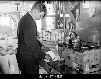 Le Coastal Command de la Royal Air Force, 1939-1945. Un membre d'équipage d'un Short Sunderland Mark I de n° 10 Squadron RAAF, la vaisselle dans la cuisine pendant le vol. Banque D'Images