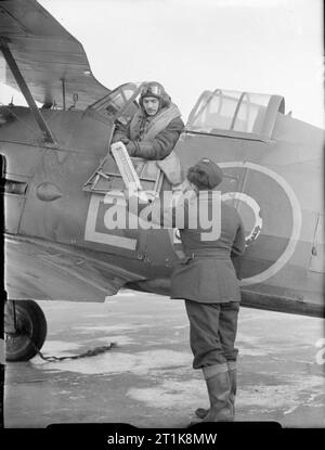 Le Coastal Command de la Royal Air Force, 1939-1945. Un homme d'équipage au sol un psychromètre à mains, le Lieutenant pilote météorologique J B Gordon de No 521 Squadron RAF en Gloster Gladiator Mark II, N5897 'E', avant qu'il quitte sur une haute-altitude THUM (Température et humidité) Vol de Bircham Newton, Norfolk. Banque D'Images