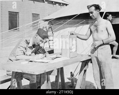 Royal Air Force au Moyen-Orient, 1944-1945. L'Aviateur-chef McLeash de Musselburgh, Écosse, au sein d'un escadron de la RAF en Afrique du Nord, baisse son papier dans l'urne à l'extérieur de l'isoloir, chapiteau pendant le vote pour l'élection générale de 1945. Banque D'Images