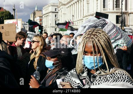 Londres, Royaume-Uni. 14 octobre 2023 plusieurs milliers de personnes, y compris des groupes de la Coalition Stop the War, des amis d’Al Aqsa, de la Communauté juive Neturei Karta, et bien d’autres, se réunissent dans le centre de Londres pour marcher contre la situation qui se développe en Israël et à Gaza après une récente escalade. Des chants de “Palestine libre” ont été entendus alors que des fusées éclairantes étaient allumées et des drapeaux agités, alors que Scotland Yard et la police métropolitaine ont mis en garde contre tout soutien au Hamas. © Simon King/ Alamy Live News Banque D'Images