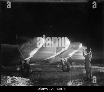 Royal Air Force- 2nd Tactical Air Force, 1943-1945. Un de Havilland Mosquito NF Mark XIII de No 604 Squadron RAF se prépare à taxy sur le périmètre tracé dans la neige fondante de B51/Lille-Vendeville, France, pour une sortie de nuit. Banque D'Images