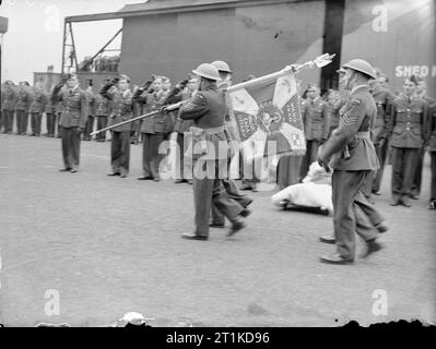 L'armée de l'air polonaise au Royaume-Uni, 1939-1945. Une fête de couleur portant le standard de l'armée de l'air polonaise passe devant les rangs des aviateurs saluants après la cérémonie de présentation à Swinderby, Lincolnshire. La norme a été faite par des femmes et leurs familles à Wilno (Vilnius), en Pologne, alors occupée par l'Armée rouge, et a été introduite clandestinement en Suède par des diplomates japonais, d'où elle a finalement atteint le Royaume-Uni en mars 1941. La devise sur la norme se lit comme suit : « mi?o?? ??da ofiary - Love exige le sacrifice. Banque D'Images