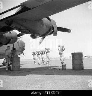 La guerre en Extrême-Orient, 1944 femmes indiennes, les ouvriers engagés dans la construction de l'aérodrome, transmettre mécaniciens travaillant sur un Royal Air Force bombardier Liberator consolidé à une base située au Bengale. Banque D'Images