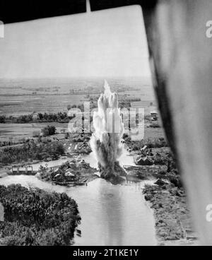 Légende AWM : Photographie prise d'un Liberator B Mark VI consolidé du No. 356 Squadron montrant une bombe explosant sur les portes d'écluse du canal Khlong Phasi Charoen près de Bangkok en Thaïlande. Banque D'Images