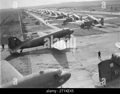 Le Commandement du transport aérien de la Royal Air Force, 1943-1945. Douglas Dakota stationné à B56/Evere, Belgique, que leurs marchandises sont déchargées dans les camions de l'armée. Le deuxième avion au premier plan est Dakota du Mark III, KG348 'HC-AO', du no 512 Squadron RAF Détachement. Banque D'Images