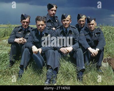 Le lieutenant de vaisseau Joe McCarthy (quatrième à partir de la gauche) et son équipage de l'escadron no 617 (les Dambusters) à la RAF Scampton, le 22 juillet 1943. L'équipage de Lancaster ED285/'AJ-T' assis sur l'herbe, s'est posé sous les nuages orageux. De gauche à droite : Sergent G Johnson; Officier pilote D A MacLean, navigateur; Lieutenant de vaisseau J C McCarthy, pilote; Sergent L Eaton, tireur. À l'arrière se trouvent le Sergent R Batson, tireur; et le Sergent W G Ratcliffe, ingénieur. L'officier de vol Dave Rodger, l'officier de bord arrière, est absent de la photo. Banque D'Images