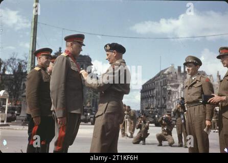 Le Maréchal Montgomery décore les généraux russes à la porte de Brandebourg à Berlin, Allemagne, 12 juillet 1945 Le commandant de la 2e communauté biélorusse, Maréchal Rokossovsky avant K est investi comme un chevalier commandeur de l'Empire britannique par le commandant du 21e Groupe d'armée, le maréchal Sir Bernard Montgomery à la porte de Brandebourg à Berlin. Trois autres généraux russes ont été décorés à cette occasion, y compris le sous-Commandant en chef de l'Armée rouge, le maréchal Joukov G. Banque D'Images