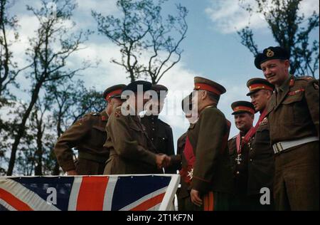 Le Maréchal Montgomery décore les généraux russes à la porte de Brandebourg à Berlin, Allemagne, 12 juillet 1945 Le sous-Commandant en chef de l'Armée rouge, le maréchal Joukov G serre la main avec le commandant du 21e Groupe d'armée, le maréchal Sir Bernard Montgomery sur le point de salut à la porte de Brandebourg, Berlin après une cérémonie au cours de laquelle le maréchal Montgomery avait investi le maréchal Joukov comme un Chevalier Grand Croix de l'Ordre du Bain et accordé d'autres décorations sur K Général Rokossovsky et maréchal Sokolovsky V de l'Armée rouge qui sont visibles à droite du Maréchal Joukov. L Banque D'Images