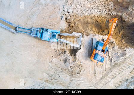 Transport de la sortie de concasseur de roche de type concassé dans une carrière minière à ciel ouvert Banque D'Images