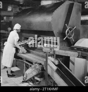 Une boulangerie moderne- le travail de l'Émerveillement Boulangerie, Wood Green, Londres, Angleterre, RU, 1944 à l'Étonnant Bakery à Wood Green, un travailleur supprime les miches de pain à partir de l'une des quatre centrales au gaz fours plaque voyageant à la boulangerie. Banque D'Images