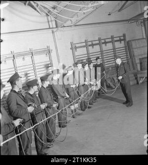 Ex-facteur fournit les canons- Formation de la marine marchande en Grande-Bretagne, 1942 au gymnase de l'établissement de formation de la Marine royale pour les marins marchands, William Charles Piper et son nouveau navire s'accouple en savoir plus sur les noeuds. L'instructeur est visible sur la droite de la photographie et Piper peut être vu, quatrième à partir de la fin de la rangée des marins, juste à droite du centre. Cette photographie a été presque certainement prises sur le HMS GORDON à Gravesend dans le Kent. Banque D'Images