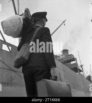 Ex-facteur fournit les canons- Formation de la marine marchande en Grande-Bretagne, 1942 William Charles Piper, après trois mois à la Marine royale de l'Institut de formation pour les marins marchands, (presque certainement le HMS GORDON à Gravesend dans le Kent), est maintenant entièrement formés et déclenche, cause en main et sac sur son épaule, de rencontrer son premier navire. Banque D'Images