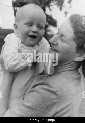 A Village Saves- National Savings in Lewknor, Oxfordshire, Angleterre, 1941 Portrait d'un souriant John Andrew, âgé de 6 mois, avec sa mère. John vaut son poids en or, car il pèse 18lb et a ?GBP18 dans les certificats d'épargne nationaux. Banque D'Images