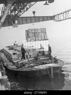 L'accumulation de l'invasion- Les préparatifs pour les débarquements du jour J, UK, 1944, à un port quelque part en Grande-Bretagne, des boîtes de rations alimentaires sont tantôt sur la jetée dans une barge en préparation pour le transport vers le deuxième front. Banque D'Images