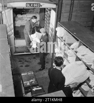 Blanchisserie en temps de guerre- les travaux de Blanchisserie Gleniffer, Catford, Londres, Angleterre, RU, 1944 à Catford en blanchisserie Gleniffer, grosses liasses de blanchisserie finis sont chargés dans un grand camion pour la livraison aux clients. Banque D'Images