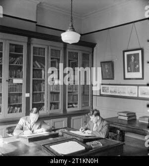 London Merchant Seamen's Home et Red Ensign Club, 1942 George Lappin (sur la droite) et fellow de la marine marchande d'écrire des lettres dans la paix et le calme de la bibliothèque de l'accueil des marins marchands et pavillon rouge Club. Banque D'Images